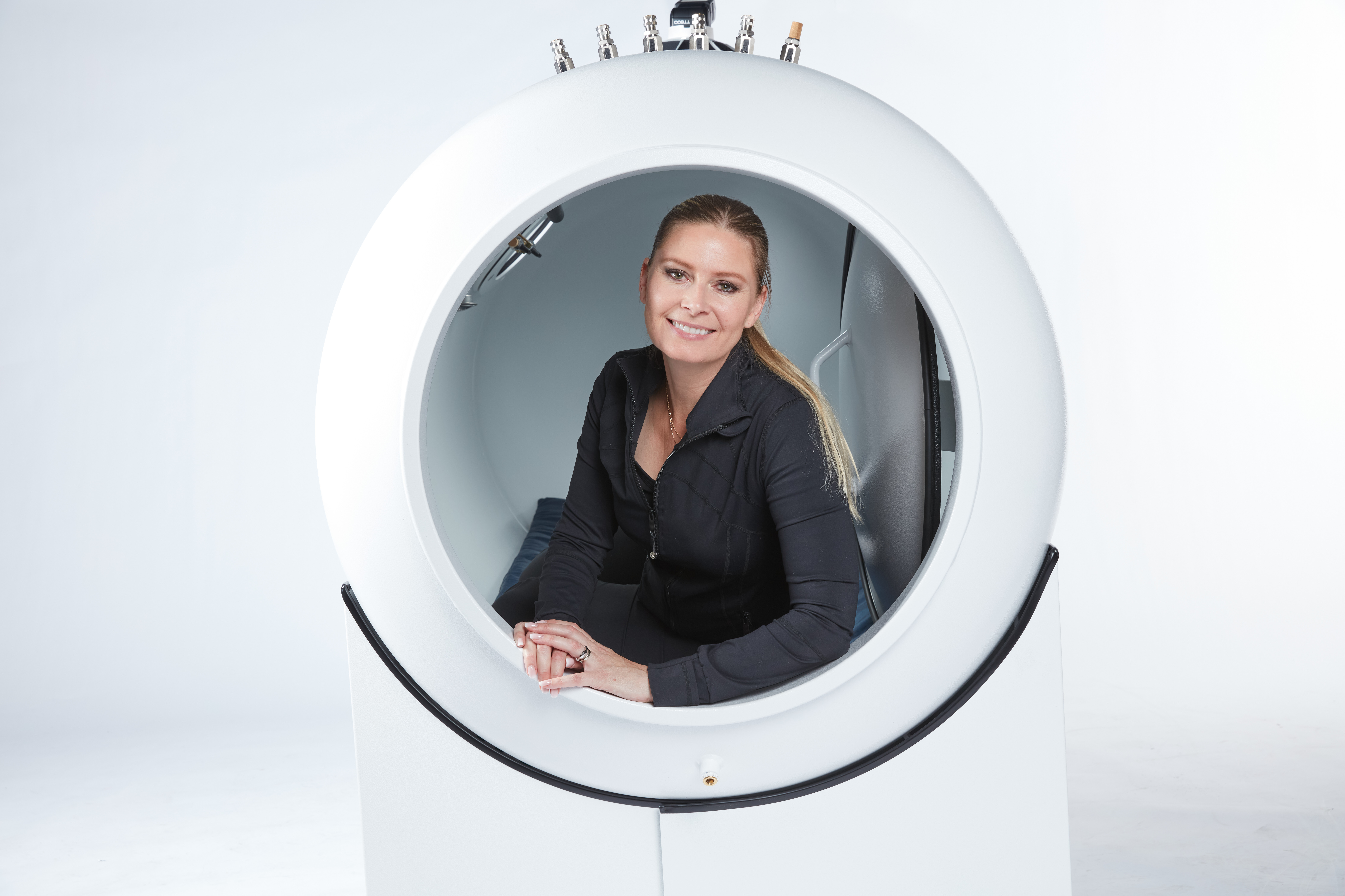 Patient smiling comfortably inside an OxyHealth Fortius 420 hard-sided hyperbaric chamber